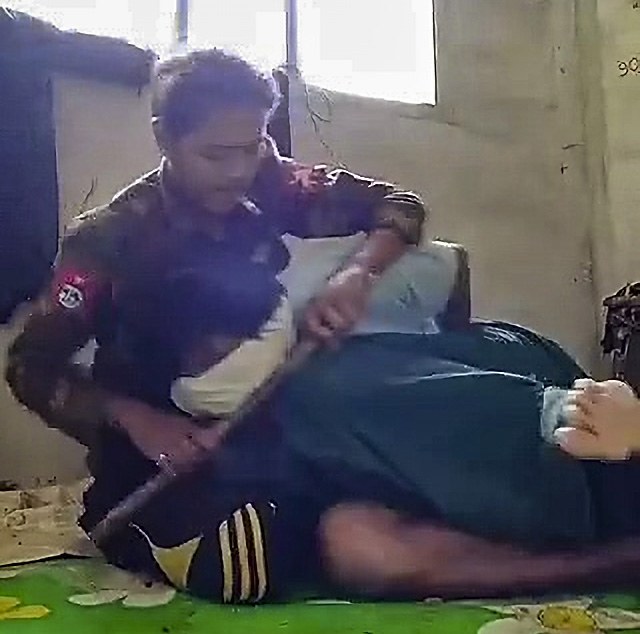 မျက်နှာတွင်အဝတ်စည်းကာ လက်နောက်ပြန်ကြိုးတုပ်ပြီး ဖမ်းဆီးခံထားရသည့်  အရပ်သားကို စစ်ကောင်စီတပ်သားက ညှဉ်းပန်းနှိပ်စက်နေစဉ်။  (RFA screenshot from video)