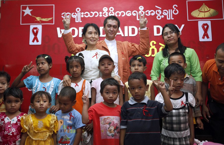 အမျိုးသားဒီမိုကရေစီအဖွဲ့ချုပ်ရုံးမှာ ၂၀၁၀ ပြည့်နှစ် ဒီဇင်ဘာ ၂ ရက်နေ့က ကျင်းပတဲ့ ကမ္ဘာ့အေအိုင်ဒီအက်စ်တိုက်ဖျက်ရေးနေ့ အခမ်းအနားမှာ  ဒေါ်အောင်ဆန်းစုကြည်နှင့် ကင်မ်အဲရစ်တို့ကို တွေ့ရစဉ်။ (Photo : Reuters)