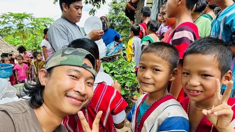 ထီးဘော်ကော် စစ်ဘေးရှောင် စာသင်ကျောင်းတွင် ကာတွန်းဆရာ ကေအက်တီအား စစ်ဘေးဒုက္ခသည်ကလေးများနှင့်အတူ ၂၀၂၃ ခုနှစ်၊ သြဂုတ်လ ၈ ရက်နေ့က တွေ့ရစဥ်။ (ကေအက်တီ ဓာတ်ပုံ)