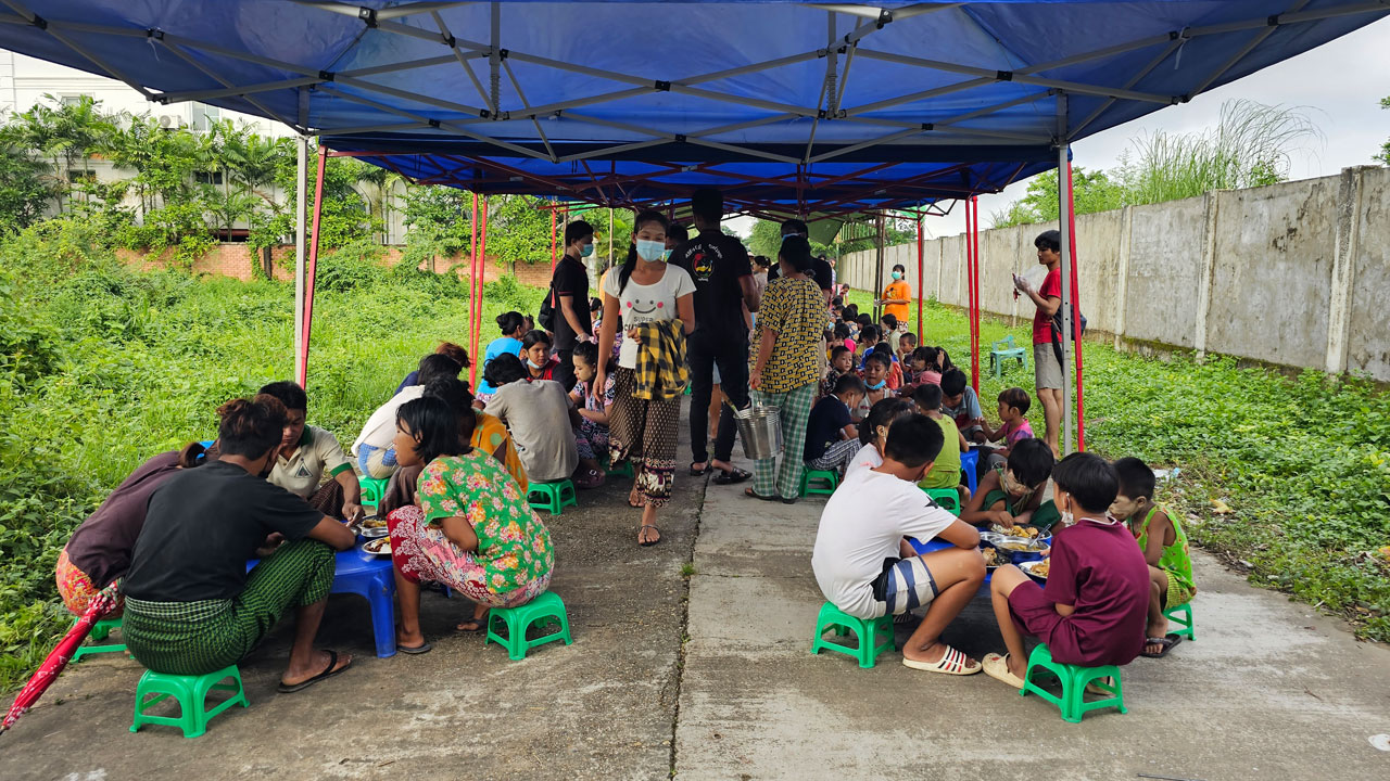 ရန်ကုန်တိုင်း၊ ဒဂုံမြို့သစ်ဆိပ်ကမ်းမြို့နယ် (၆၇) ရပ်ကွက်တွင် ၂၀၂၃ ခုနှစ်၊ သြဂုတ်လ ၆ ရက်နေ့က Team KG အဖွဲ့ ကျွေးသည့် ထမင်းနှင့်ဟင်းများကို လာရောက်စားသုံးသူများအား တွေ့ရစဉ်။ (Photo: RFA)