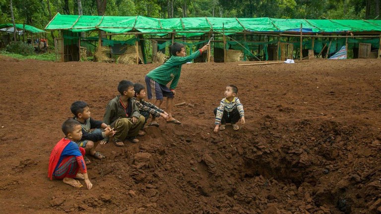 ၂၀၂၃ ခုနှစ်၊ ဇွန်လ ၄ ရက်နေ့က ကယားပြည်နယ်၊ ဒီးမော့ဆိုအနောက်ခြမ်းက စစ်ဘေးဒုက္ခသည်စခန်း ဗုံးကြဲတိုက်ခိုက်ခံရအပြီး ဗုံးကျင်းအနီးတွင် တွေ့ရသည့် ကလေးငယ်များ။ (Karenni's Voice Photo)
