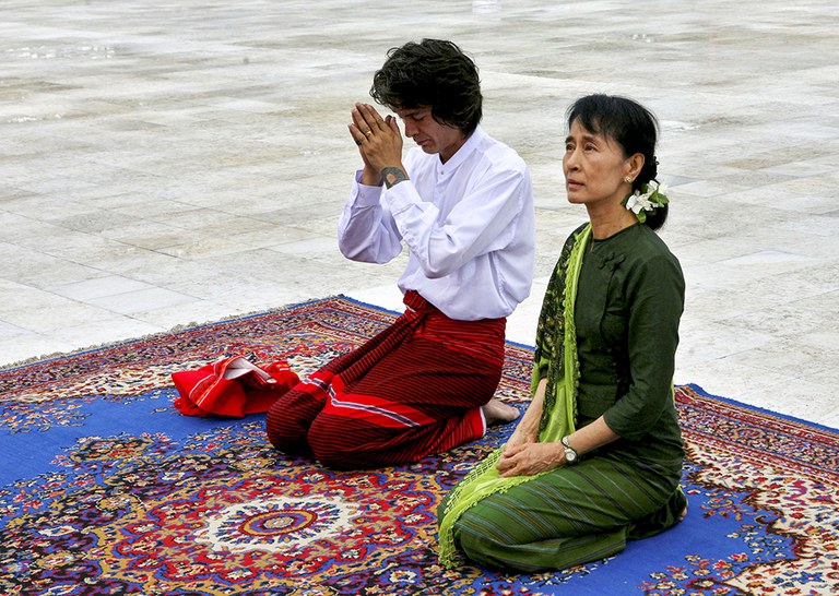 ၂၀၁၁ ခုနှစ်က ဒေါ်အောင်ဆန်းစုကြည်ရဲ့ သားငယ် ကင်မ်အဲရစ် မြန်မာနိုင်ငံကို လာရောက်ပြီး မိခင်ဖြစ်သူ ဒေါ်အောင်ဆန်းစုကြည်နှင့်အတူ ရွှေတိဂုံဘုရားကို သွားရောက်ဖူးမြော်ခဲ့စဉ်။ (Photo: AFP)