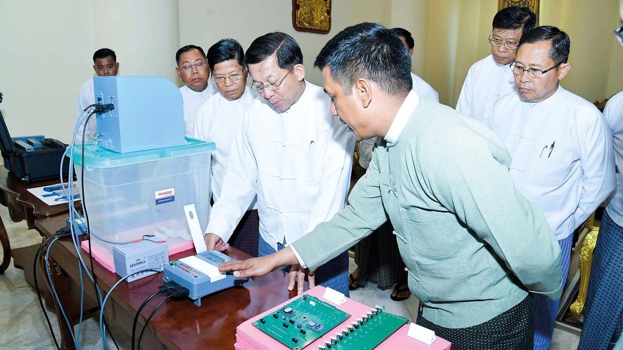 အီလက်ထရွန်နစ် မဲပေးစနစ်အသုံးပြုပုံနှင့် စက်ပိုင်းဆိုင်ရာများကို ကြည့်ရှုနေသည့် စစ်ကောင်စီဥက္ကဋ္ဌ ဗိုလ်ချုပ်မှူးကြီး မင်းအောင်လှိုင်အား ၂၀၂၃ ခုနှစ်၊ ဖေ‌ဖော်ဝါရီလ ၉ ရက်နေ့က တွေ့ရစဉ်။ (Photo: Myanmar Military)
