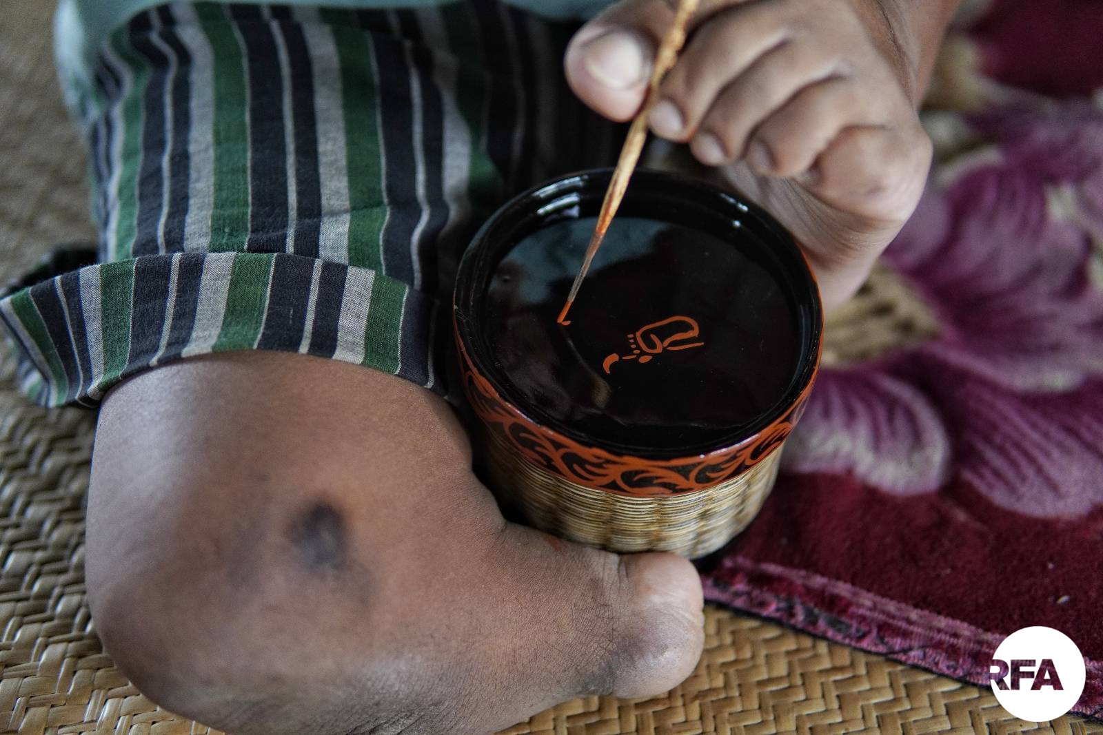 ကိုထွေးရဲ့ အမှတ်တံဆိပ်ဖြစ်တဲ့ ခြေထောက်တစ်ဖက်နဲ့ ပန်းချီဆွဲတဲ့ စုတ်တံပါတဲ့ပုံကို ရေးဆွဲနေတာပါ။