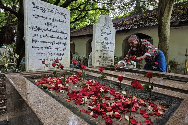 အာဇာနည်ခေါင်းဆောင် ဝန်ကြီးဦးရာဇတ်နဲ့ ရဲဘော်ကိုထွေးတို့ အုတ်ဂူမှာ ၂၀၂၃ ခုနှစ် ဇူလိုင် ၁၉ ရက်နေ့က လာရောက်ဂါရ၀ပြုသူ တစ်ဦးကိုတွေ့ရစဉ်။ (Photo : RFA)