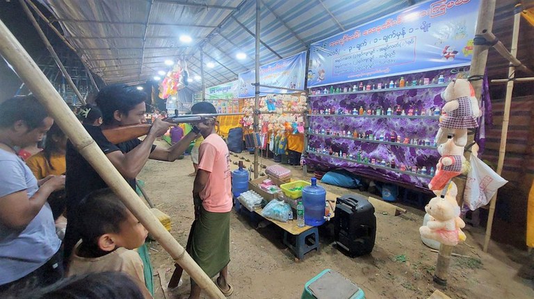 မန္တလေးတိုင်း ညောင်ဦးမြို့ ရွှေစည်းခုံဘုရားအနီးတွင် ရောင်းချနေသည့် ဆယ့်နှစ်ပွဲစျေးသည်များနှင့် ပွဲဈေးလာသူများကို  ၂၀၂၃ ခုနှစ် ဇွန်လ ၁ ရက်နေ့ညက တွေ့ရစဉ်။ (Photo: RFA)