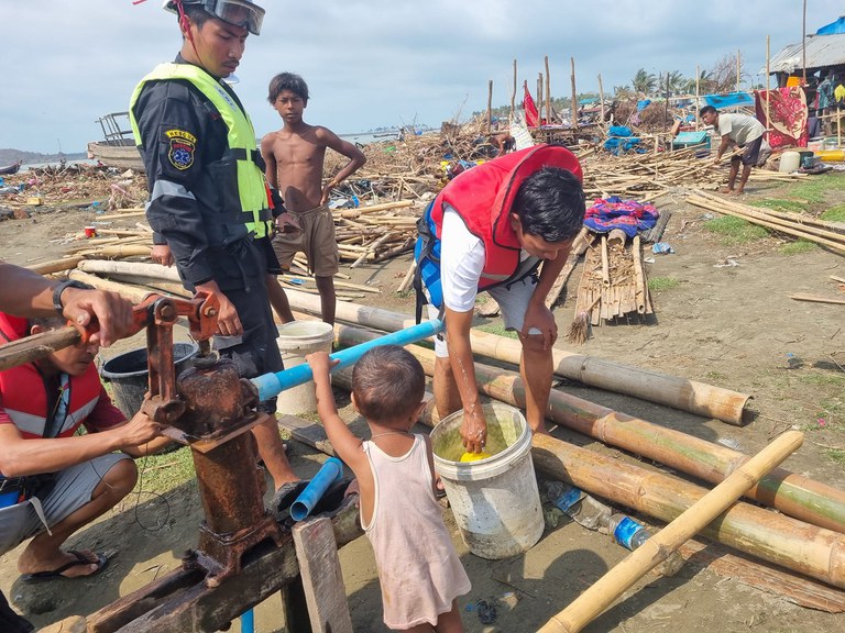 မုန်တိုင်းဒဏ်ခံပြည်သူများ သောက်ရေသန့်ရရှိရေးအတွက် ကူညီပေးနေသူများ။ (Photo: Facebook/ Wai Hun Aung)