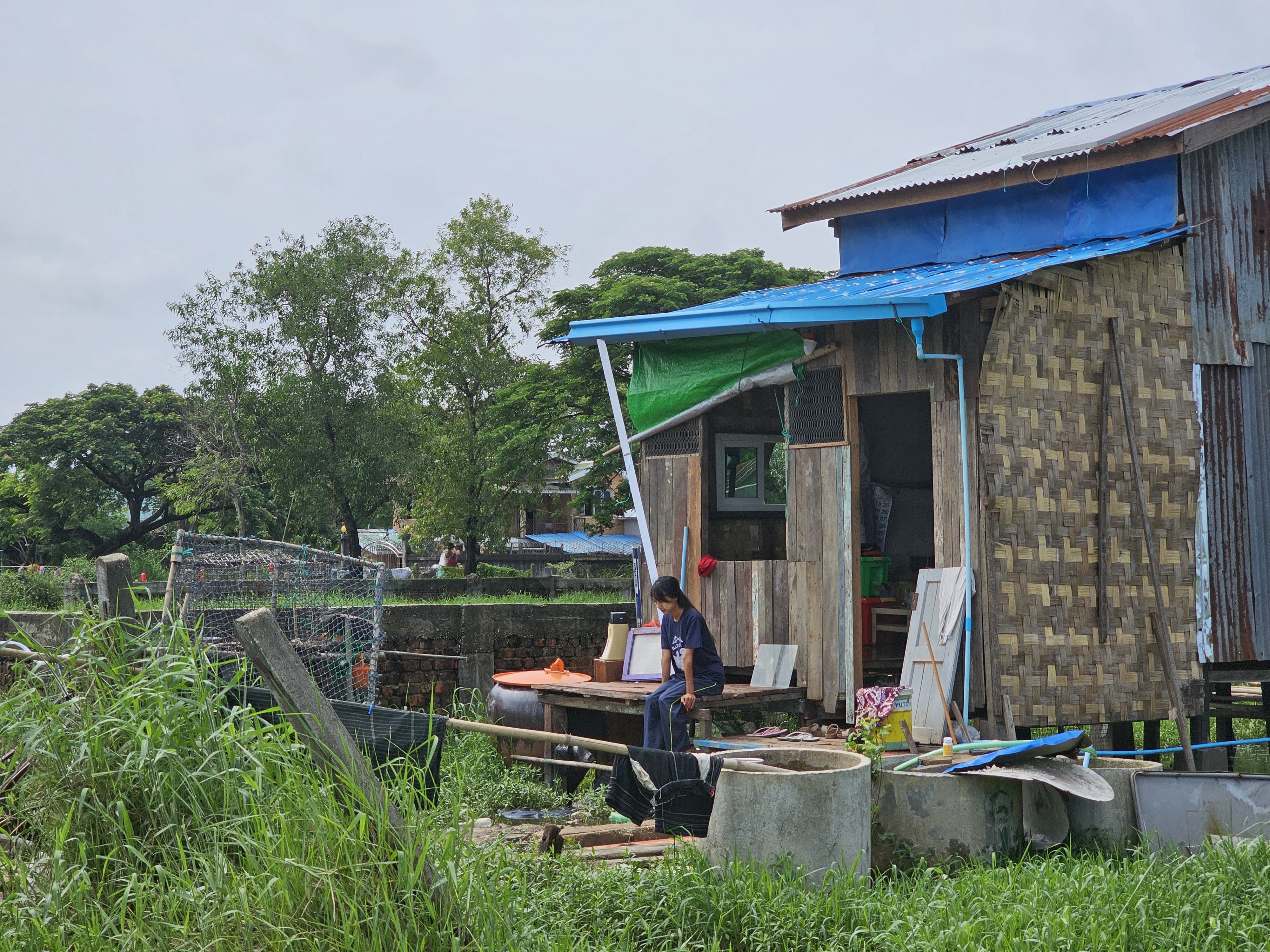 နေအိမ်ရှေ့တွင် ထိုင်နေသည့် ကာယအားကစားမယ် မသဲစုအား ၂၀၂၃ ခုနှစ်၊ ဇွန်လ ၉ ရက်နေ့က တွေ့ရစဉ်။ (Photo: RFA)