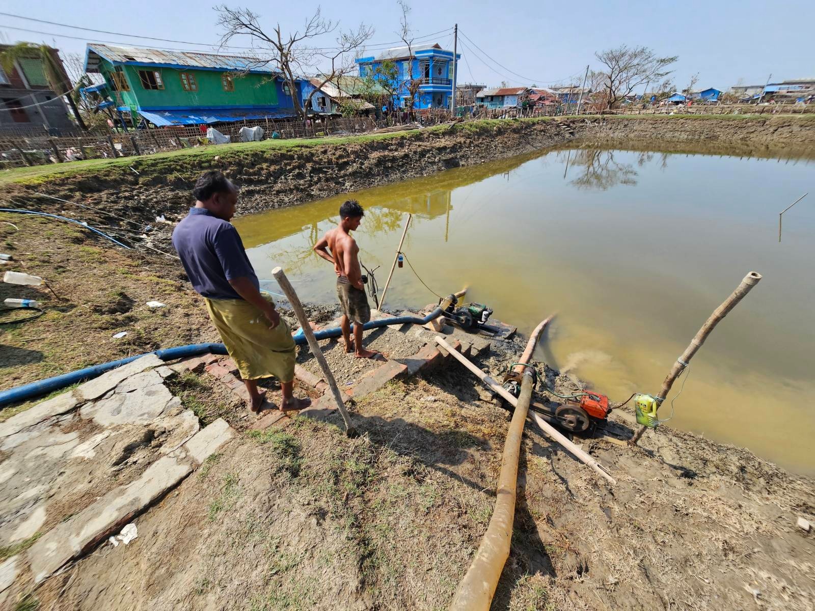 ရခိုင်ပြည်နယ်၊ စစ်တွေမြို့နယ်၊ ကျေးတောပိုက်ဆိပ်ကျေးရွာမှ သောက်သုံးရေကန်တစ်ကန်မှာ ရေငံများ စုပ်ထုတ်နေကြသည်ကို ၂၀၂၃ ခုနှစ်၊ မေလ ၂၂ ရက်နေ့က တွေ့ရစဉ်။ (Photo: RFA)