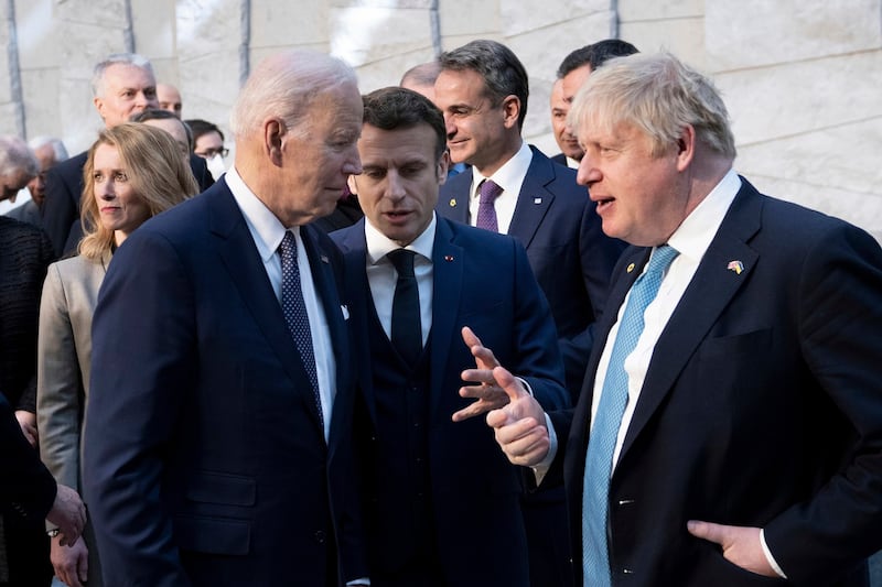 美国总统拜登(左起)与法国总统马克龙和英国首相约翰逊在北约峰会上谈话。(美联社)