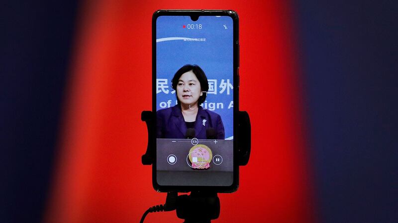 图为,一部智能手机画面显示,中国外交部发言人华春莹在例行记者会上。(美联社)