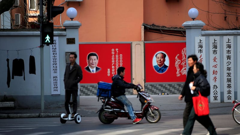 图为上海一家单位门内挂有习近平与毛泽东像的墙壁宣传画。(路透社)