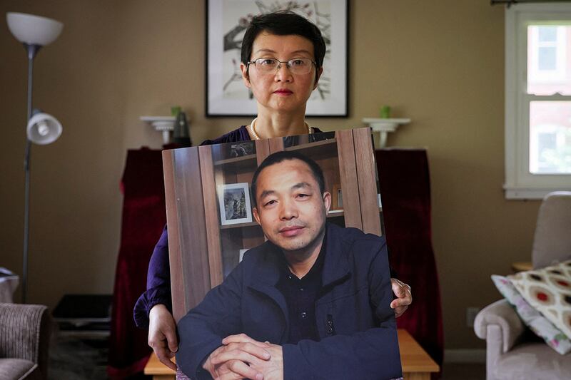 被失踪的中国人权律师丁家喜之妻罗胜春手捧先生的照片(路透社图片)