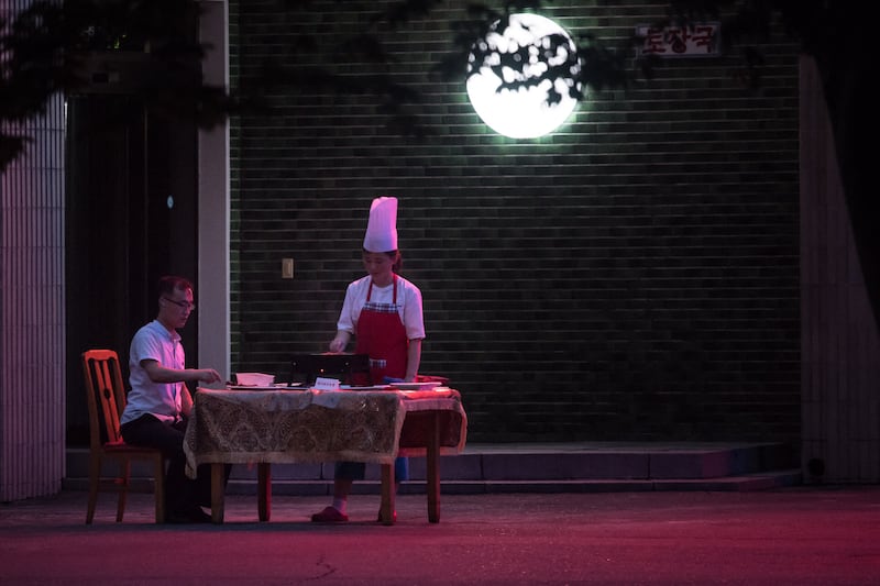 한 남성이 평양에 위치한 식당 야외 테이블에서 식사하는 모습.