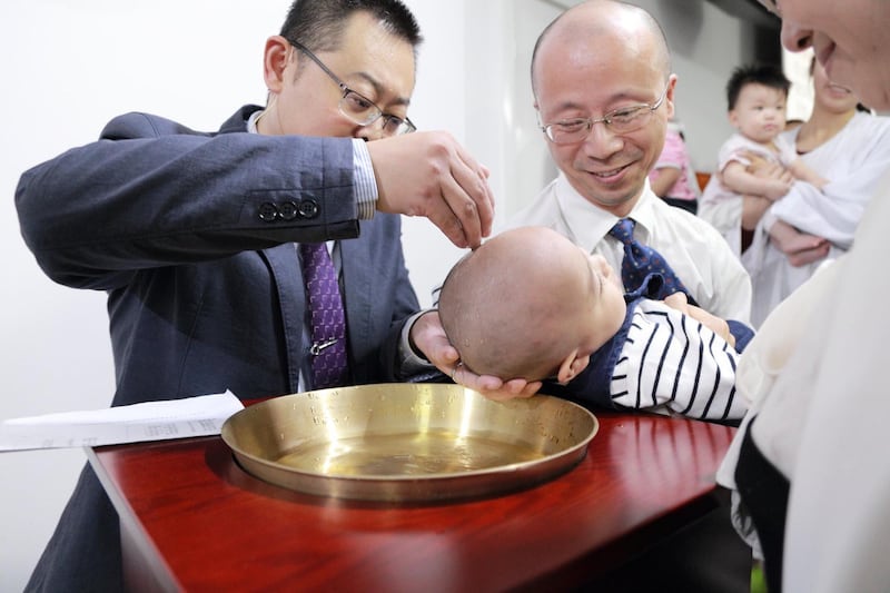 资料图片:秋雨教会被关押中的王怡牧师(左)过去为小文施洗。(廖强提供)