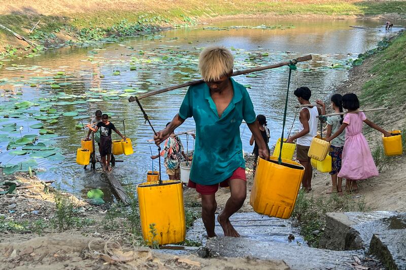 ရန်ကုန်မြစ်တစ်ဘက်ကမ်း ဒလမြို့နယ်တွင် နေထိုင်သည့် ပြည်သူများ သောက်သုံးရေခပ်ယူနေကြသည်အား ၂၀၂၃ ခုနှစ် မေလ ၂ ရက်နေ့က တွေ့ရစဉ်။ (Photo: RFA)