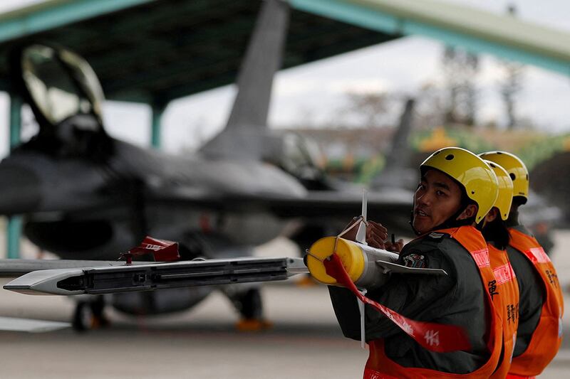 2018 年 1 月 30 日,在台湾军事基地演习中,空军机组人员举起AIM-9响尾蛇空对空飞弹,将其装载到战斗机上。(路透社)