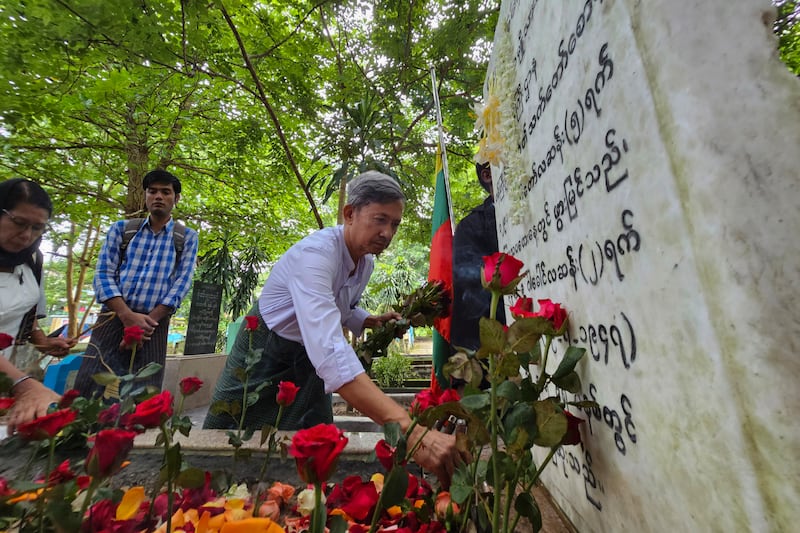 အာဇာနည်ခေါင်းဆောင် ဝန်ကြီးဦးရာဇတ်နဲ့ ရဲဘော်ကိုထွေးတို့ အုတ်ဂူမှာ ၂၀၂၃ ခုနှစ် ဇူလိုင် ၁၉ ရက်နေ့က လာရောက် ဂါရ၀ပြုသူတစ်ဦးကို တွေ့ရစဉ်။ (Photo : RFA)