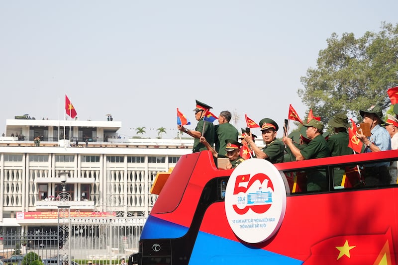 Vietnam War veterans on an open bus pass the Independence Palace during a parade to commemorate the 50th anniversary of the end of the Vietnam War in Ho Chi Minh City, April 30, 2025.