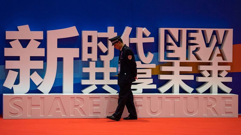 上海举办的中国国际进口博览会上,一名保安走近“新时代,共享未来”的标语。(美联社)