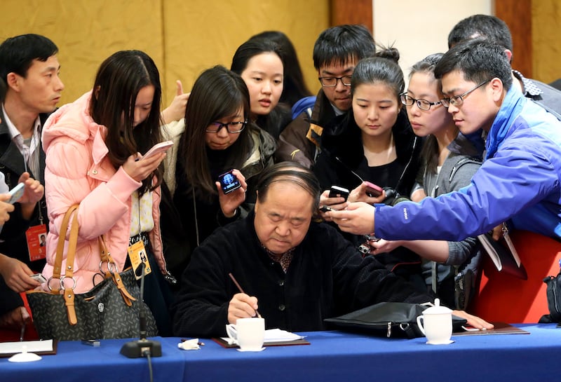 Chinese novelist Mo Yan, the 2012 Nobel Prize Laureate for Literature and a delegate of the Chinese People's Political Consultative Conference (CPPCC), is surrounded by journalists after a group discussion of the CPPCC in Beijing, March 4, 2014.