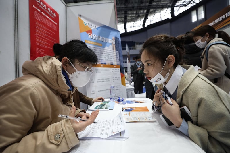 2021 年 3 月 10 日的照片显示求职者在中国中部湖北省武汉市参加招聘会。(法新社)