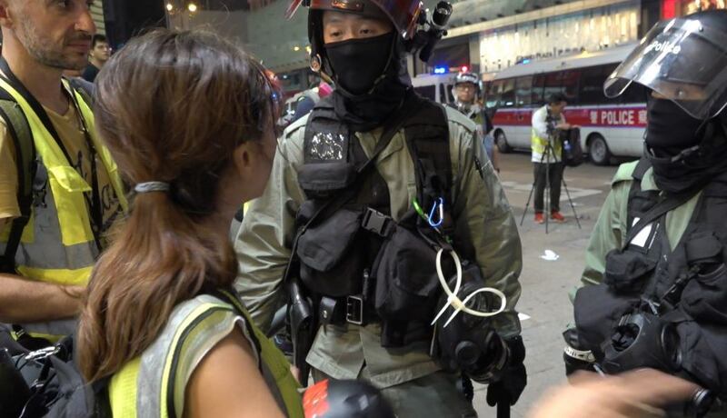 资料图片:2019年10月27日,英语网媒Hong Kong Free Press一名自由摄影记者May James在旺角采访期间被捕。(视频截图/STP)