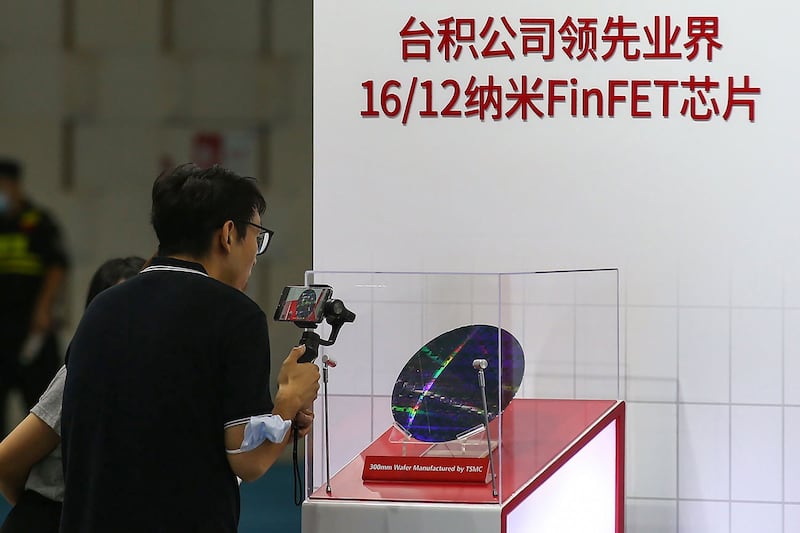 中芯国际落后于台积电技术约三代。图为2020年8月26日,南京举行2020年世界半导体大会上,一位访客为台积电(TSMC)的芯片拍照。(法新社)