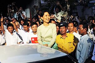 နေအိမ်အကျယ်ချုပ်မှ လွတ်လာပြီးနောက် ပါတီ တာဝန်များကို ပြန်လည် ထမ်းဆောင်ရန် ပထမဆုံးနေ့အဖြစ် နိုဝင်ဘာ ၁၅ ရက်က ဒေါ်အောင်ဆန်းစုကြည် အမျိုးသား ဒီမိုကရေစီ အဖွဲ့ချုပ် ဌာနချုပ်ရုံးသို့ ရောက်ရှိလာစဉ် လူထု ပရိသတ်က ဝိုင်းဝန်း ဆီးကြို နှုတ်ဆက်နေပုံ ဖြစ်ပါသည်။ (Photo: AFP)