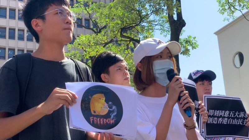 港生文庭山绘制插画,示威者拿伞对抗国家武器。(记者 黄春梅摄)