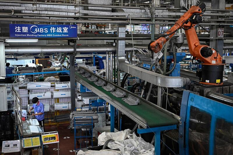 图为工人在美的家用空调广州工厂的生产线上工作。(法新社)