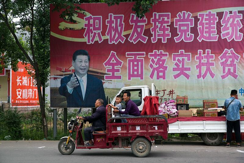 河南省平顶山市的居民经过宣传脱贫海报。(美联社)