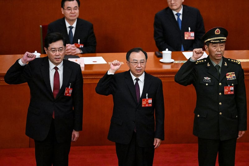 2023年3月12日,全国人大第五次全体会议在北京人民大会堂举行,新当选的中国国务委员秦刚(左)、国务委员兼国务院秘书长吴政隆(中)、国务委员李尚福宣誓就职。(美联社)