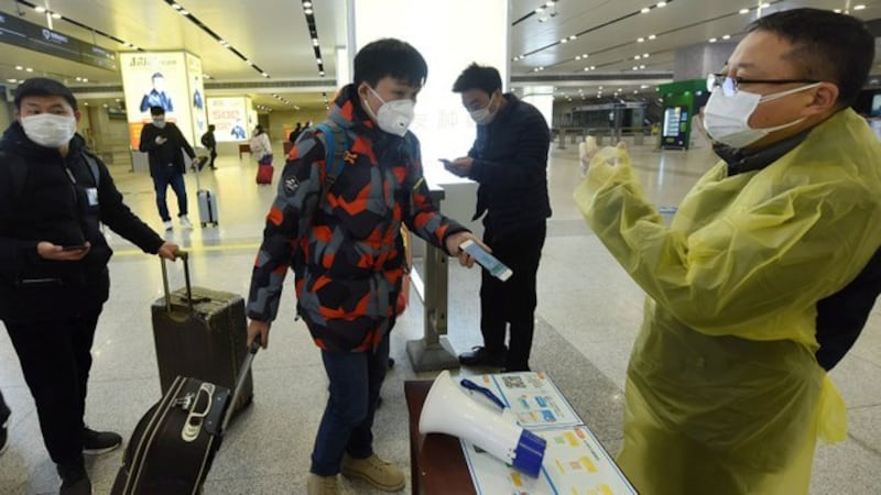 2020年2月17日,浙江省杭州市一名旅客向火车站检疫人员出示手机中的绿色健康码以证明健康状况。 (路透社)