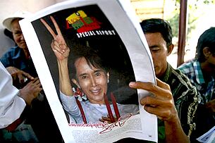 ဒီမိုကရေစီ ခေါင်းဆောင် ဒေါ်အောင်ဆန်းစုကြည် လွတ်မြောက်လာသည့် သတင်းကို နိုဝင်ဘာ ၁၅ ရက်က ပုဂ္ဂလိက ဂျာနယ်တစောင်တွင် ဖတ်ရှုနေသူတဦး ဖြစ်ပါသည်။ ထိုသတင်းကို အကျယ်တဝင့် ဖော်ပြသည့် စာနယ်ဇင်း ၉ ခုကို စာပေစိစစ်ရေးက ထုတ်ဝေခွင့် နှစ်ပတ်အထိ ပိတ်ပင်ခဲ့သည်။ (Photo: AFP)
