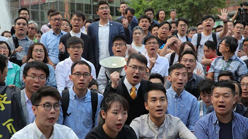 新当选的香港区议会部分民主派议员2019年11月25日聚集在香港理工大学附近(美联社)