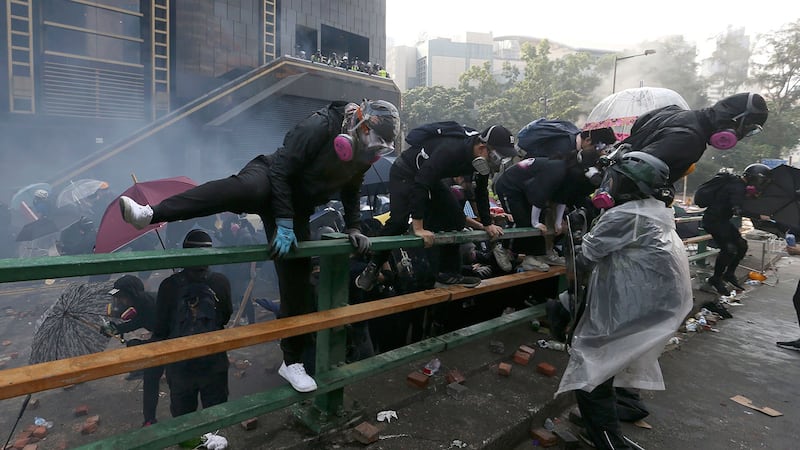 2019年11月18日,示威者在香港香港理工大学与警察发生冲突时爬上了栏杆。(美联社)