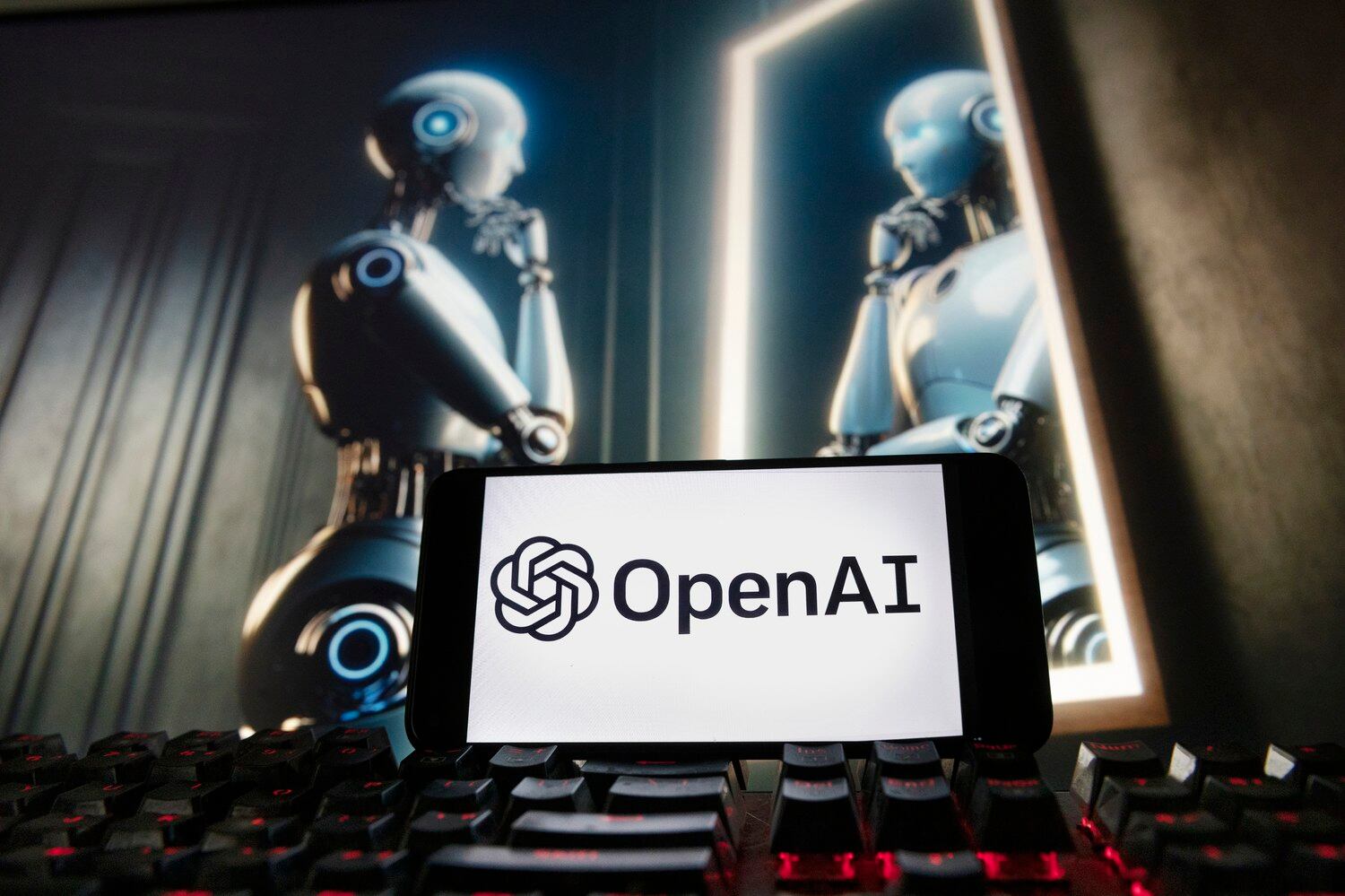 ChatGPT의 Dall-E 텍스트-이미지 모델을 통해 생성된 컴퓨터 모니터 이미지와 함께 OpenAI 로고가 휴대폰에 표시되고 있다.