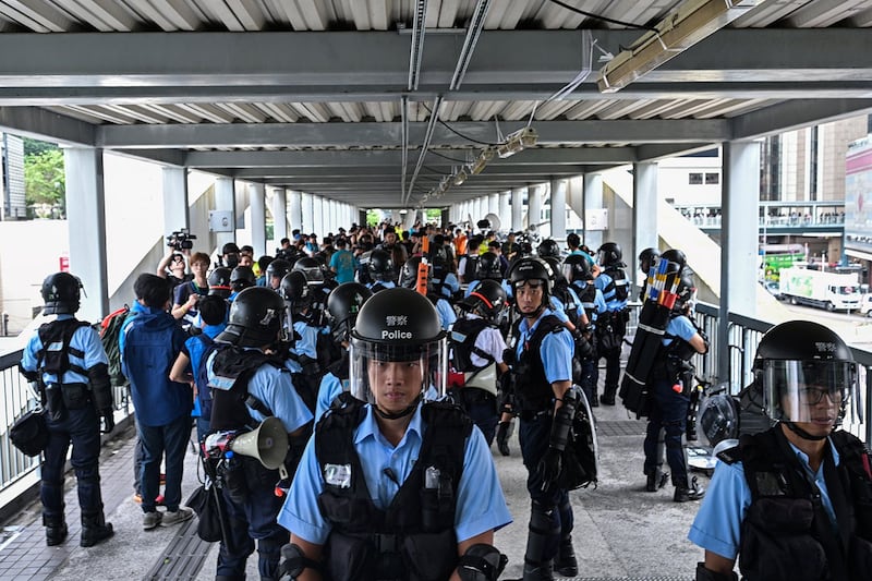 2019年6月13日,示威者在香港立法会外反《逃犯条例》,警察以暴力手段驱离示威民众后,警方在政府总部附近的天桥上守卫。(法新社)