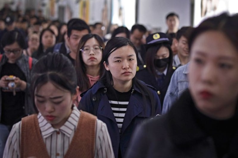 据中国民政部2022年的统计显示,中国结婚人数连续8年下降,到2021年度,结婚人数低于800万,成为36年有相关数据统计以来的最低水平。图为,在北京上下班高峰时段走进地铁站的年轻人。(美联社资料图片)