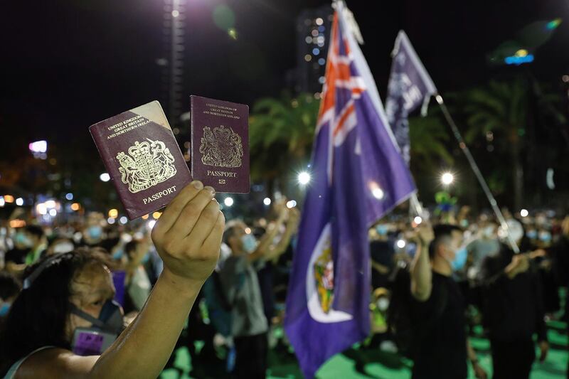 2020 年 6 月 4 日,一名香港示威者手举英国国民海外护照(BNO)。(路透社)