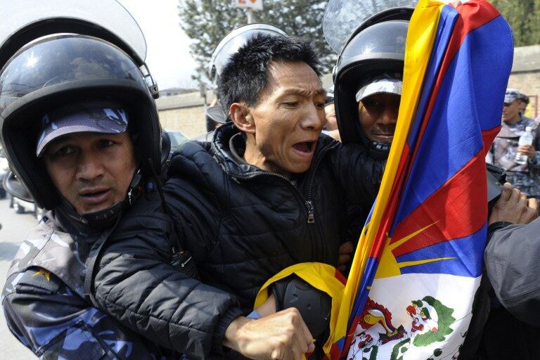 བལ་ཡུལ་གྱི་རྒྱ་ནག་གཞུང་ཚབ་མདུན་ངོ་རྒོལ་བྱེད་མཁན་ཉེན་རྟོག་པས་འཇུ་བཟུང་བྱེད་བཞིན་པ། ༢༠༡༤།༣།༡༠
