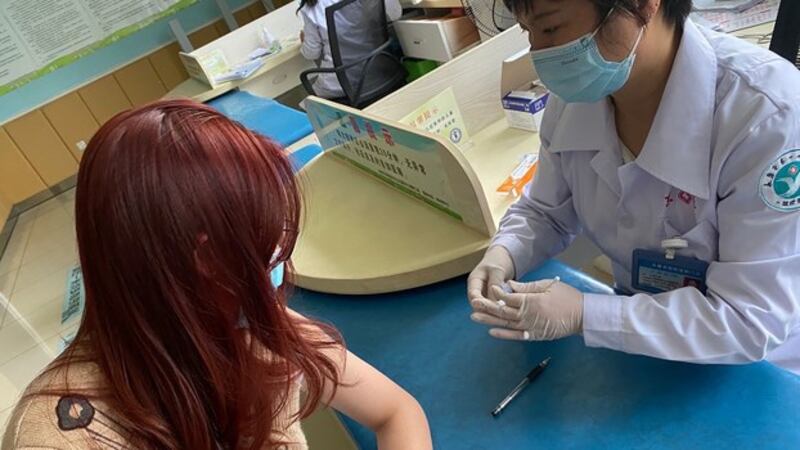一名中国学生在接受注射新冠疫苗(法新社)