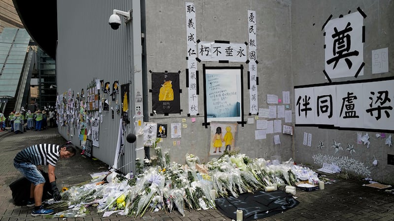 一名女子在清理香港立法会大楼外的一个场地。(美联社)