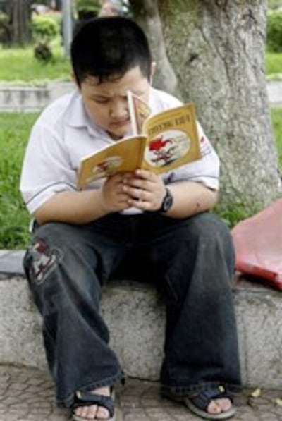 Cậu học sinh đọc sách tại công viên ở Hà Nội