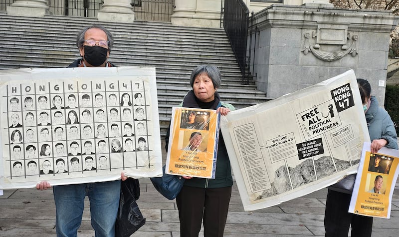 民众拿着四十七名个民主派骨干分子的头像和事件说明图板,向街头路人说明四十七人案的意义。 (记者柳飞拍摄)