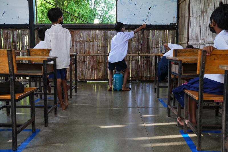 ကိုဗစ်-၁၉ ကပ်ရောဂါကြောင့် နှစ်နှစ်ကြာပိတ်ထားခဲ့သည့် စာသင်ခန်းအတွင်း ပိုးသတ်ဆေးဖြန်းနေသည့် မြန်မာကလေးငယ်တစ်ဦးကို ၂၀၂၂ ဇွန်လ ၁ ရက်နေ့က တွေ့ရစဉ်။ (Photo: Suntorn Chongcharoen/BenarNews)
