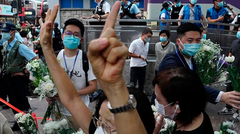 2020年8月31日,一名民众在香港地铁太子站外打出了“五大诉求缺一不可”的手势。(美联社)