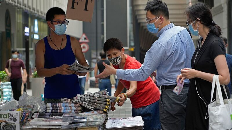 2021 年 6 月 18 日,人们在香港市中心的街道上购买 《苹果日报》。 (美联社)