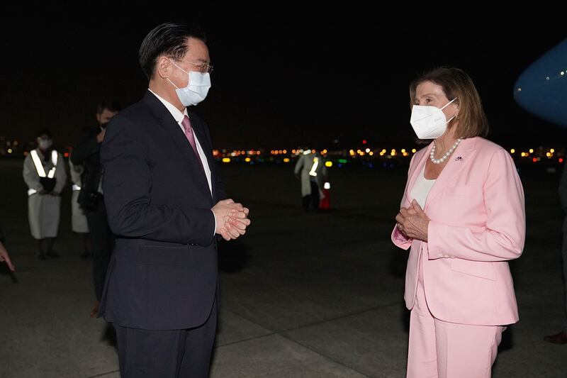 2022 年 8 月 2 日,台湾外交部长吴钊燮(左)在台北松山机场迎接美国会众议院议长佩洛西。(美联社)